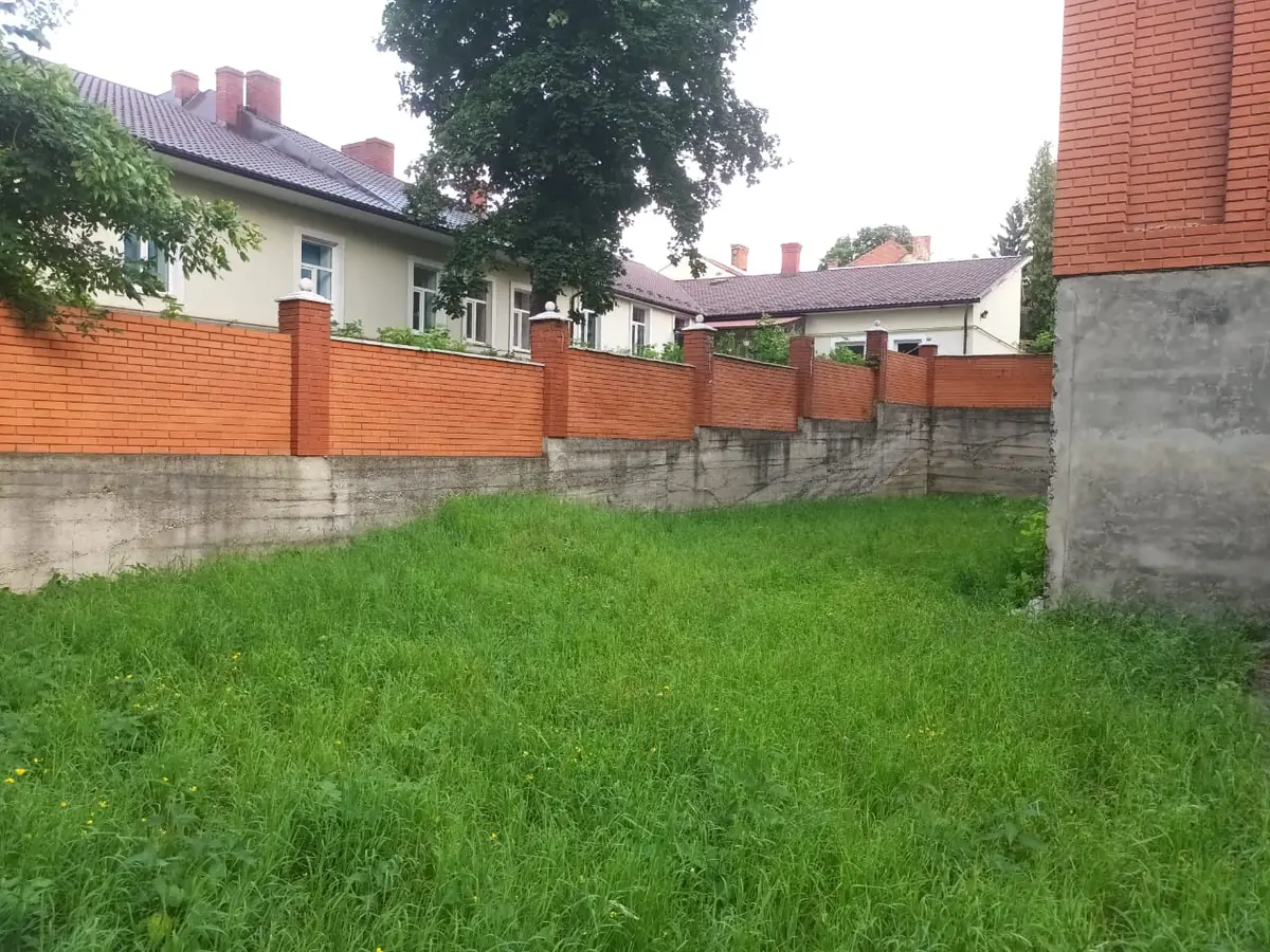 Двір готелю: цегляний паркан і зелена ділянка